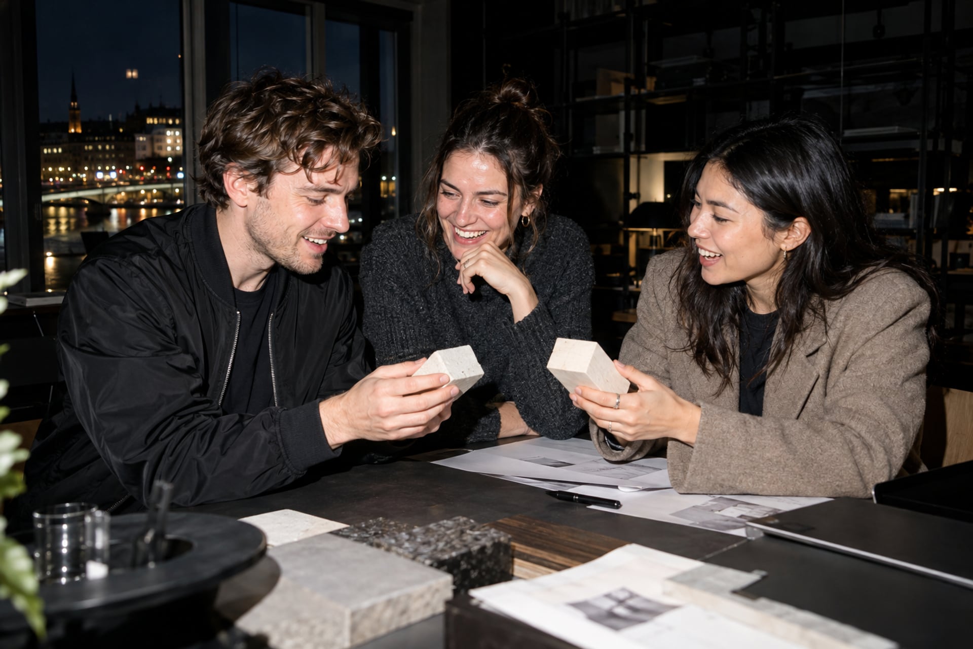 Friends compare small prototypes at a Stockholm workshop after dark.