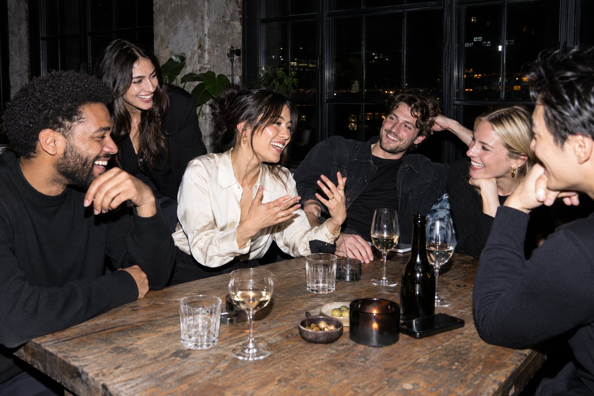 Founders share a laugh around a table in a Stockholm loft after dark.