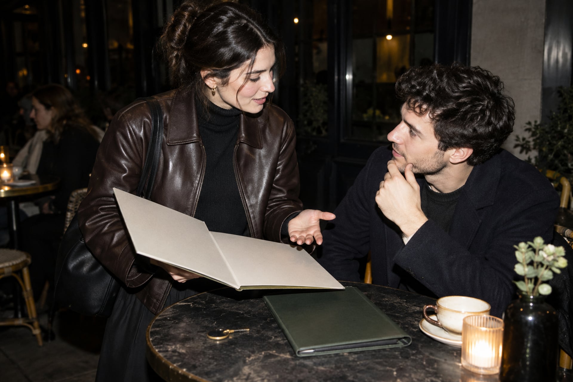 Founders compare an open and closed folder at a London cafe after dark.